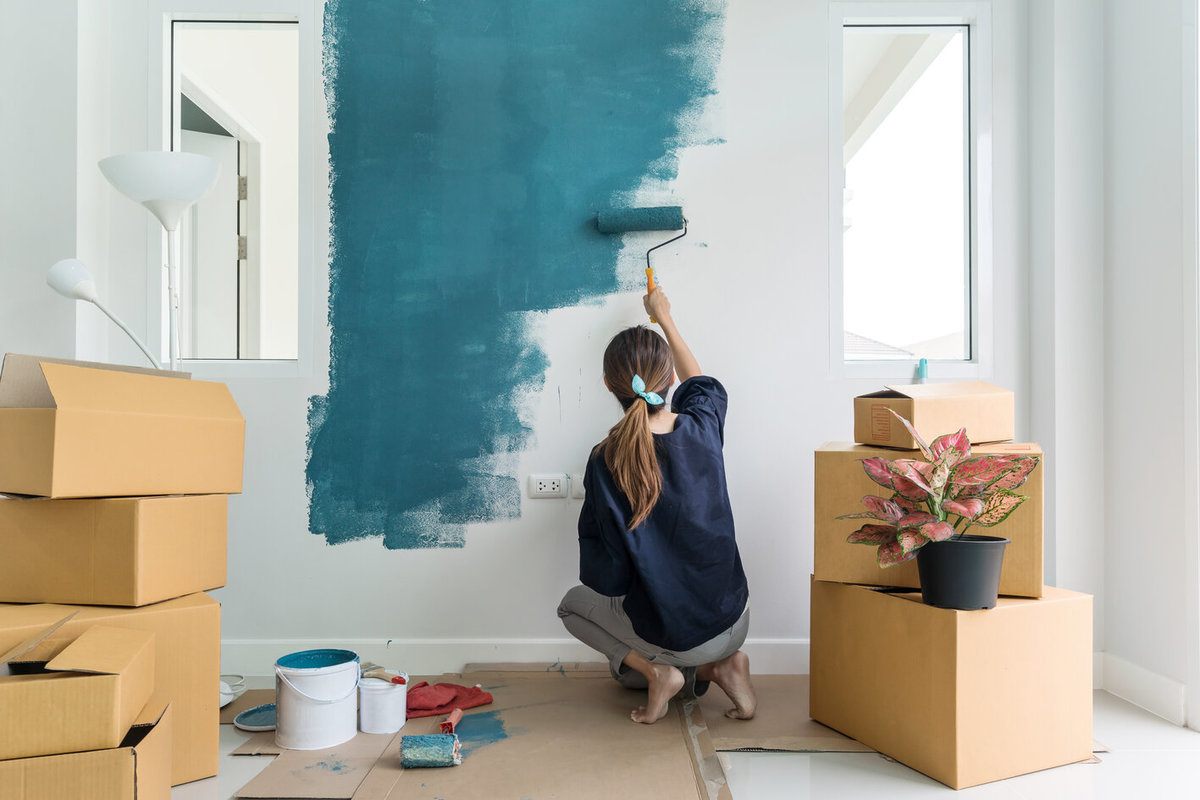 Woman Painting Interior Wall With a Paint Roller