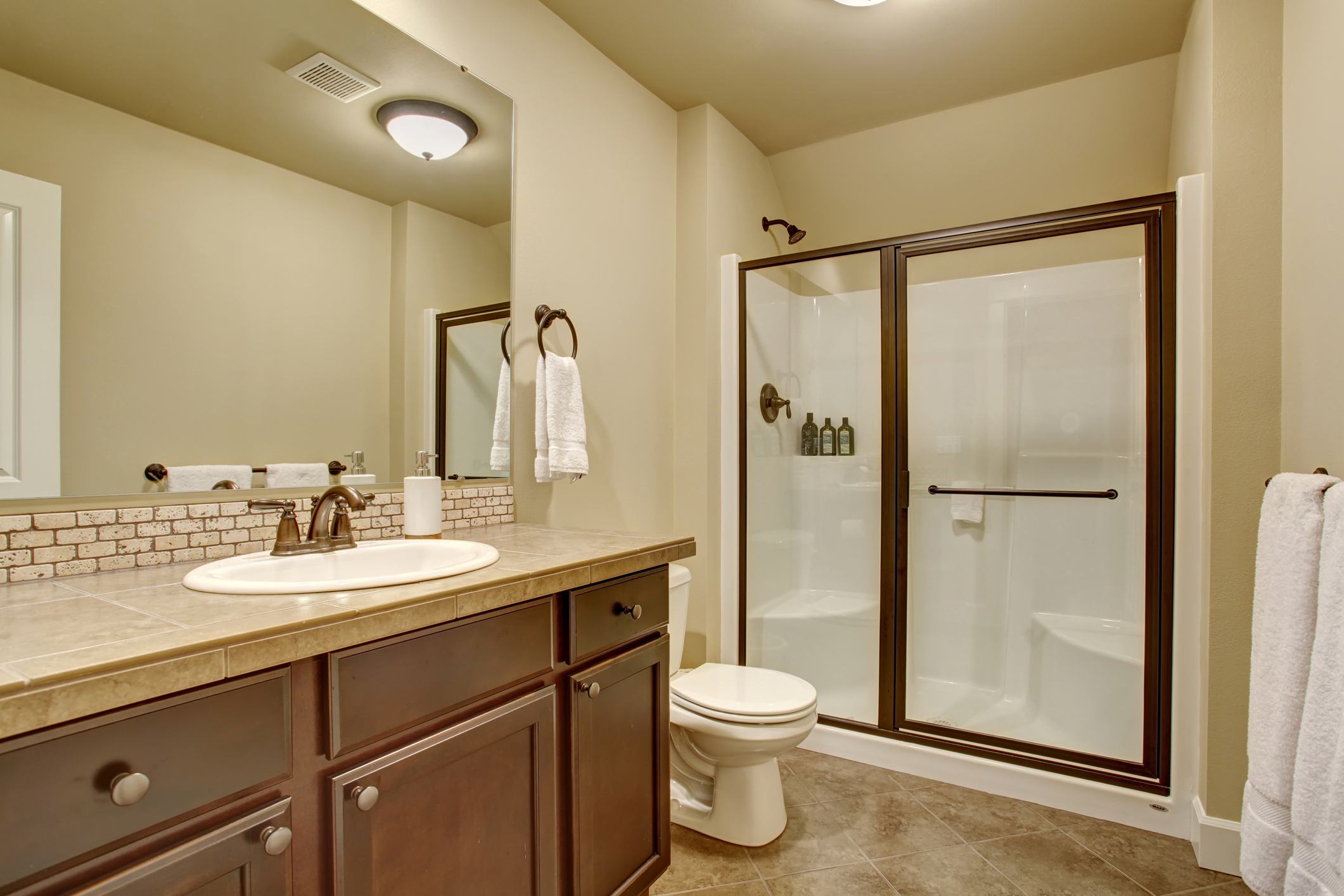 Elegant bathroom with mosaic tile floor and cream earth-toned walls.