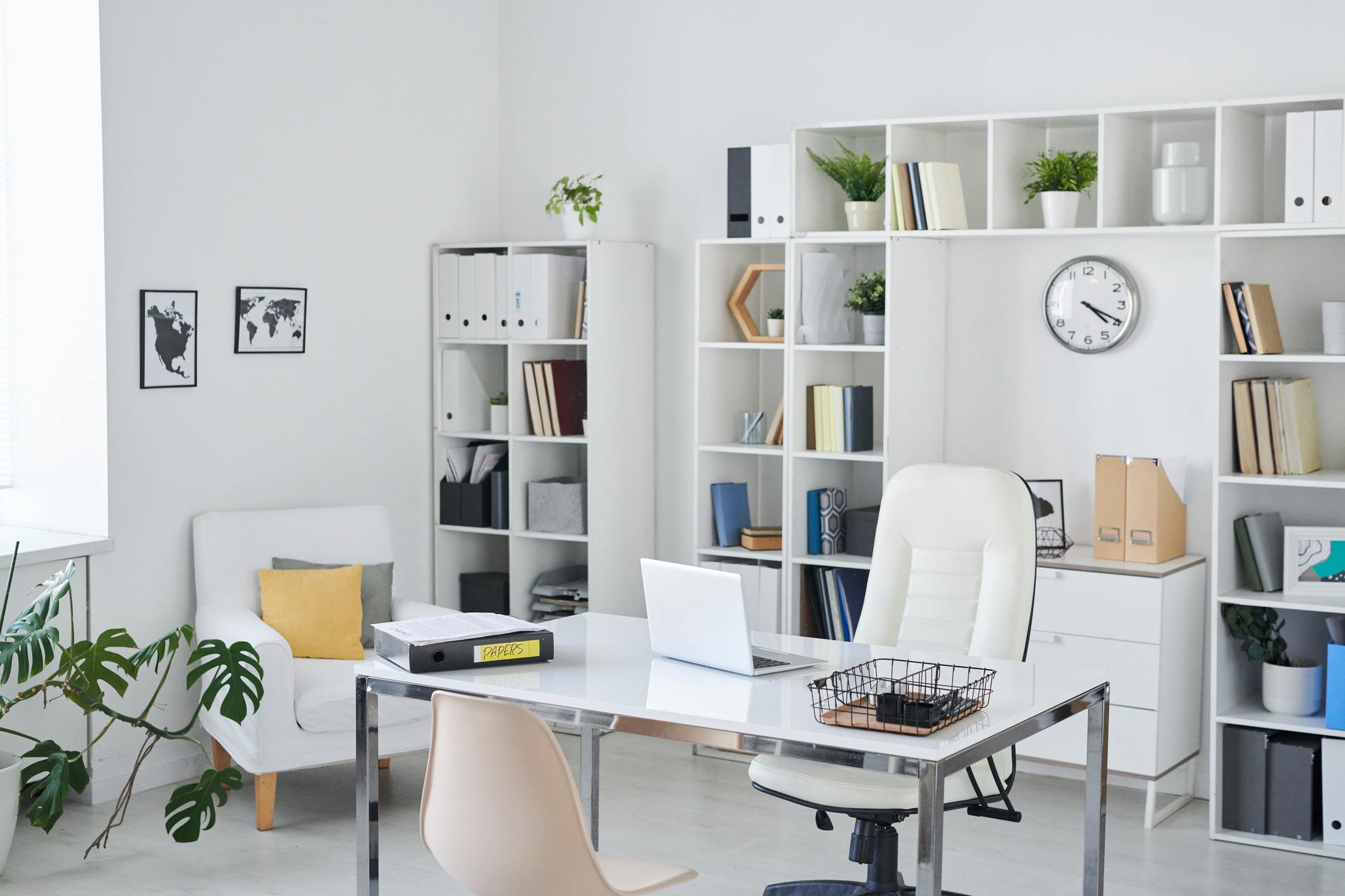 Professional home office with a desk, seating, shelves, and minimalistic decor.
