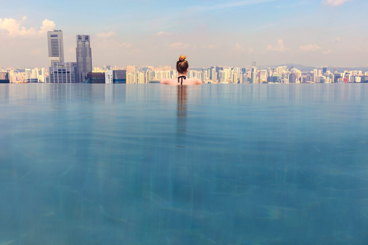 Woman bathing in an infinity pool located on a rooftop