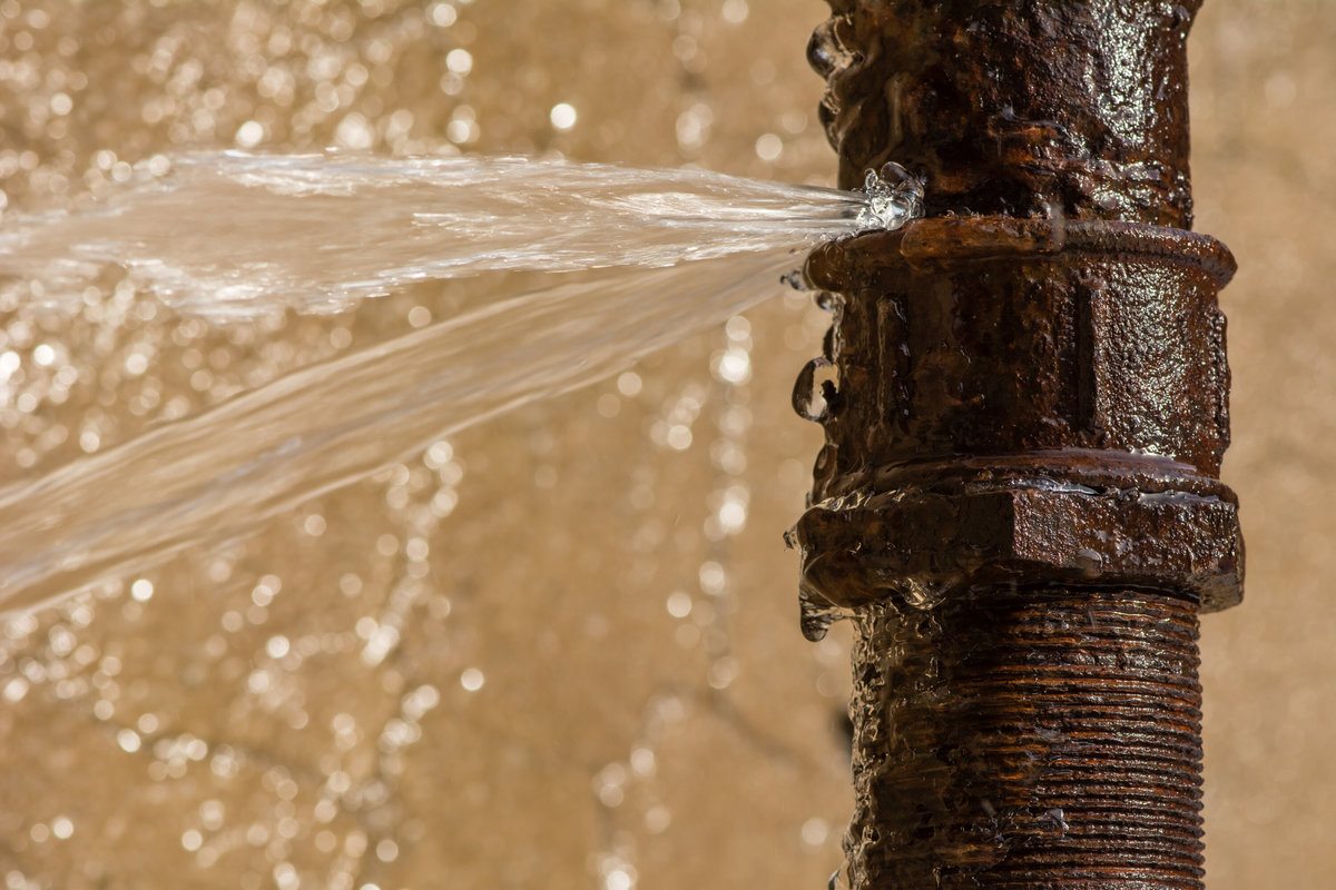 Water Bursting Out of a Corroded and Rusty Pipe