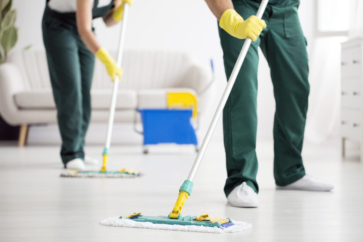 Professionals wiping the floor using mops