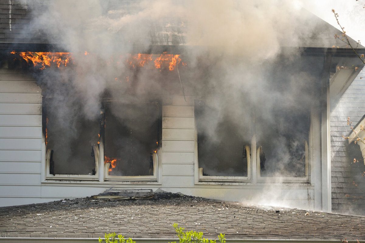 House in Fire With Flames Coming Out the Windows Under the Eaves