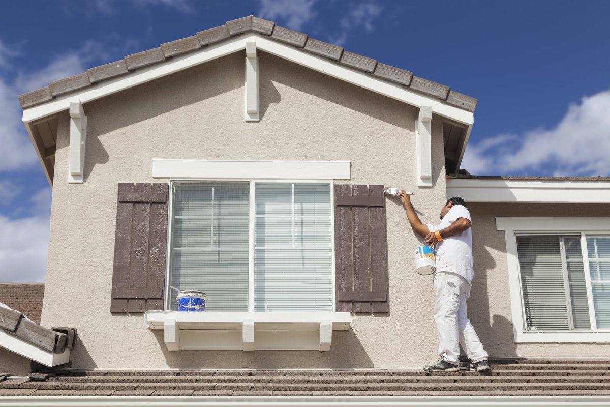 House Painter Painting the Trim and Shutters of a Home