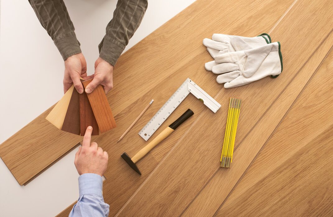 Carpenter Showing Wooden Baseboard Swatches to a Customer Choosing a Colored Flooring