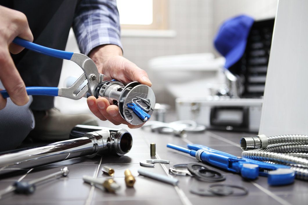 Plumber Repairing a Toilet in a Bathroom